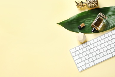 Creative flat lay composition with tropical leaf and computer keyboard on color background