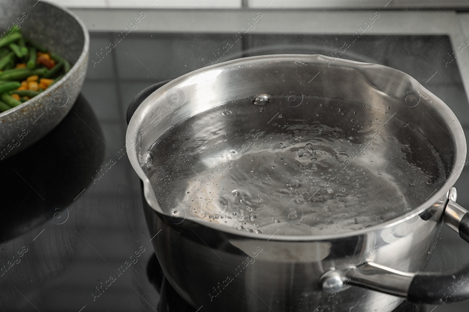 Photo of Pot with boiling water on electric stove, closeup