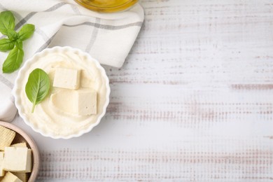 Photo of Delicious tofu sauce and basil on white wooden table, flat lay. Space for text