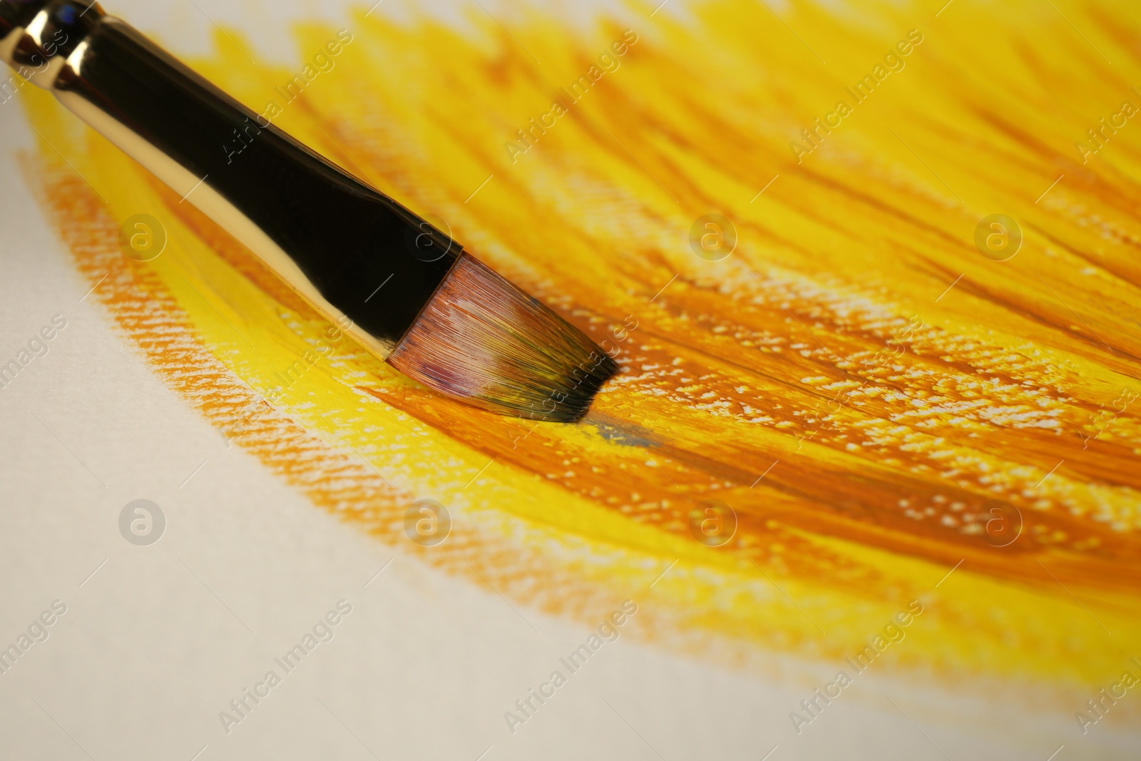 Photo of Strokes of colorful paints and brush on white canvas, closeup