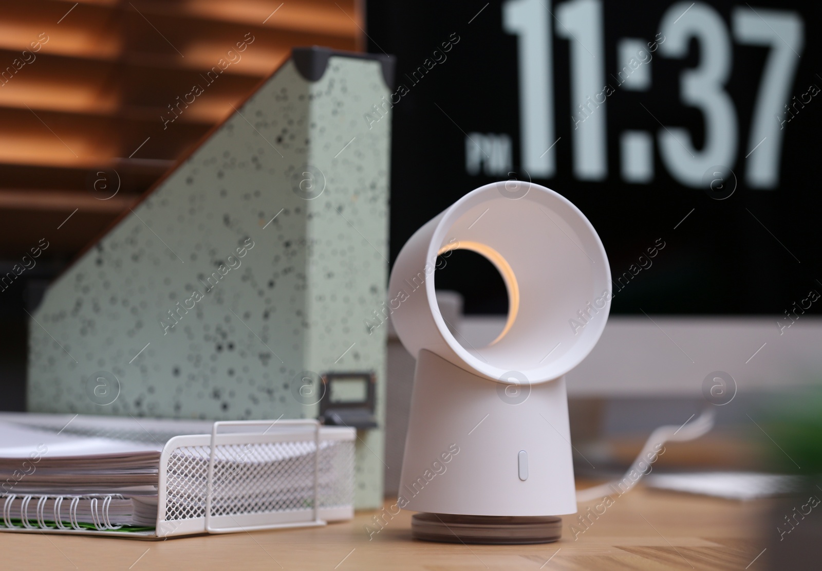 Photo of Modern electric fan on table in office