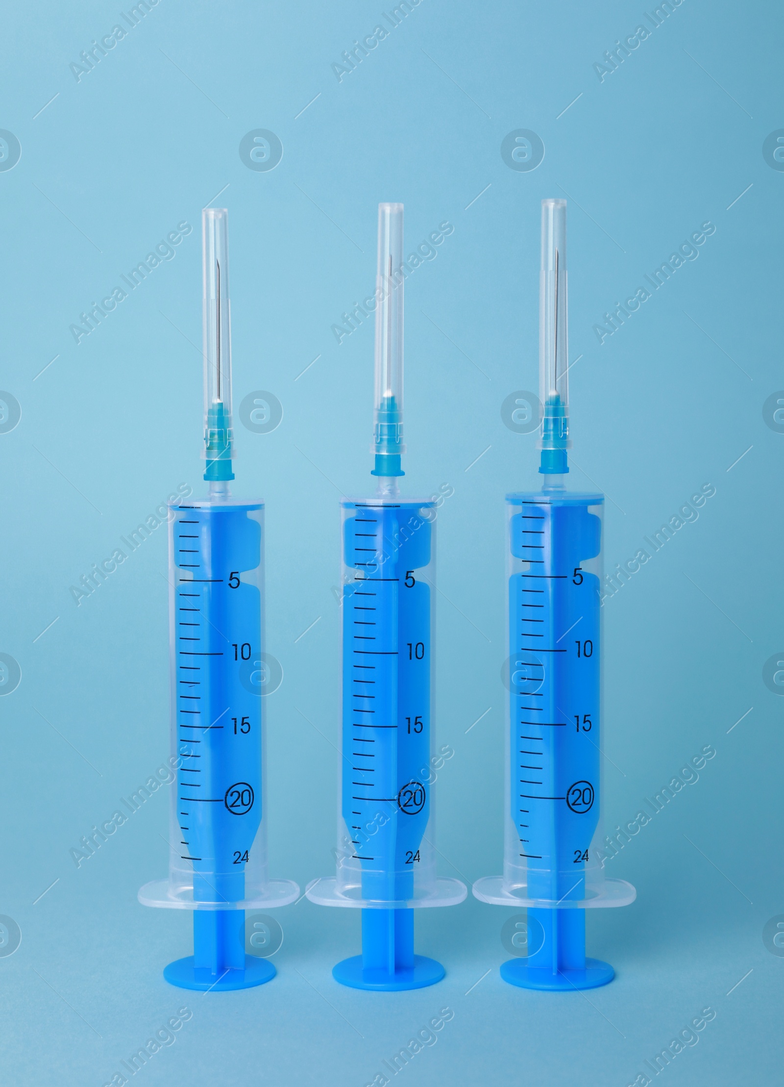 Photo of Disposable syringes with needles on light blue background