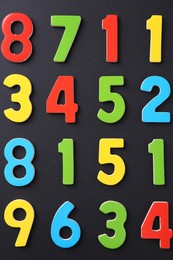 Colorful numbers on black background, flat lay