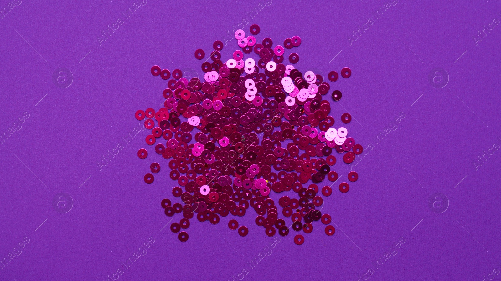 Photo of Pile of bright sequins on purple background, top view