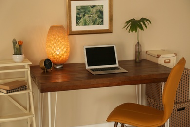 Stylish workplace with laptop on table in office