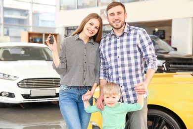 Photo of Young family holding car key in salon