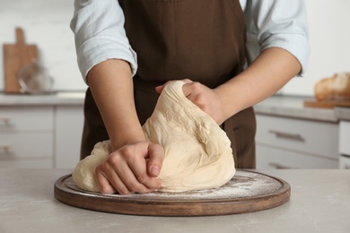 Photo of Female baker preparing bread dough at table, closeup