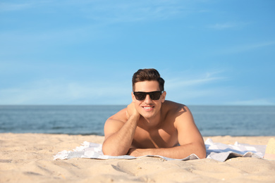 Photo of Happy man with slim body resting on beach