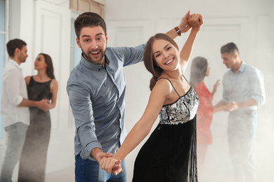Photo of Lovely young couple dancing together at party