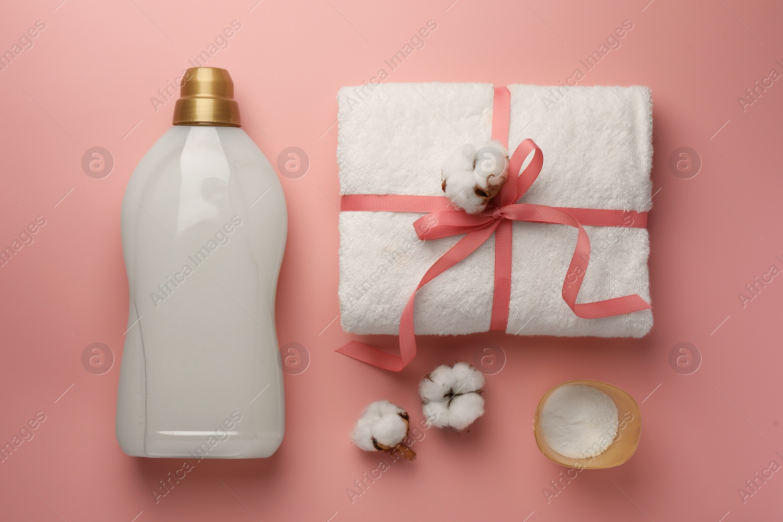 Flat lay composition with bottle of fabric softener on pink background Photo of Flat lay composition with bottle of fabric softener on pink background