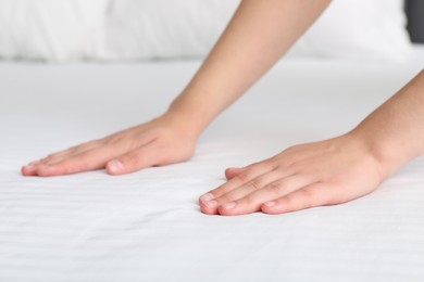 Photo of Woman touching white soft mattress, closeup view