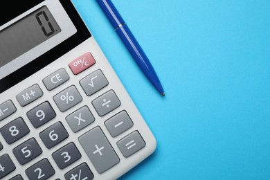 Calculator and pen on light blue background, flat lay with space for text