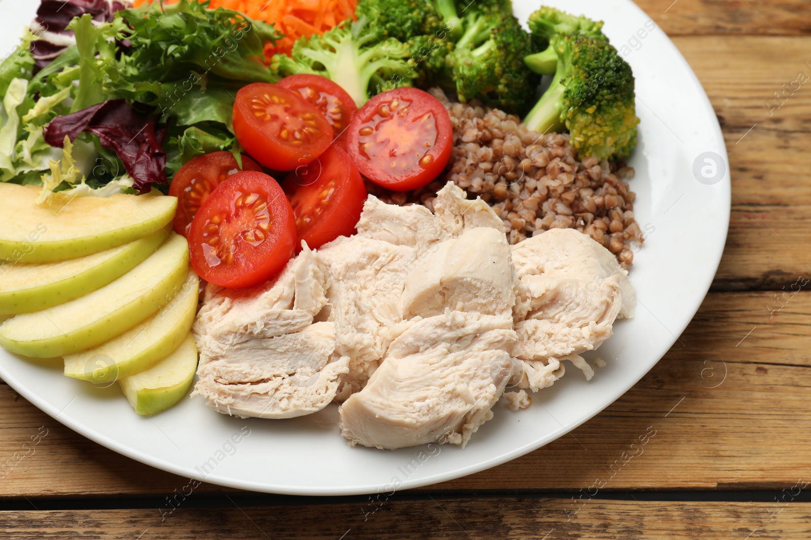 Photo of Balanced diet and healthy foods. Plate with different delicious products on wooden table