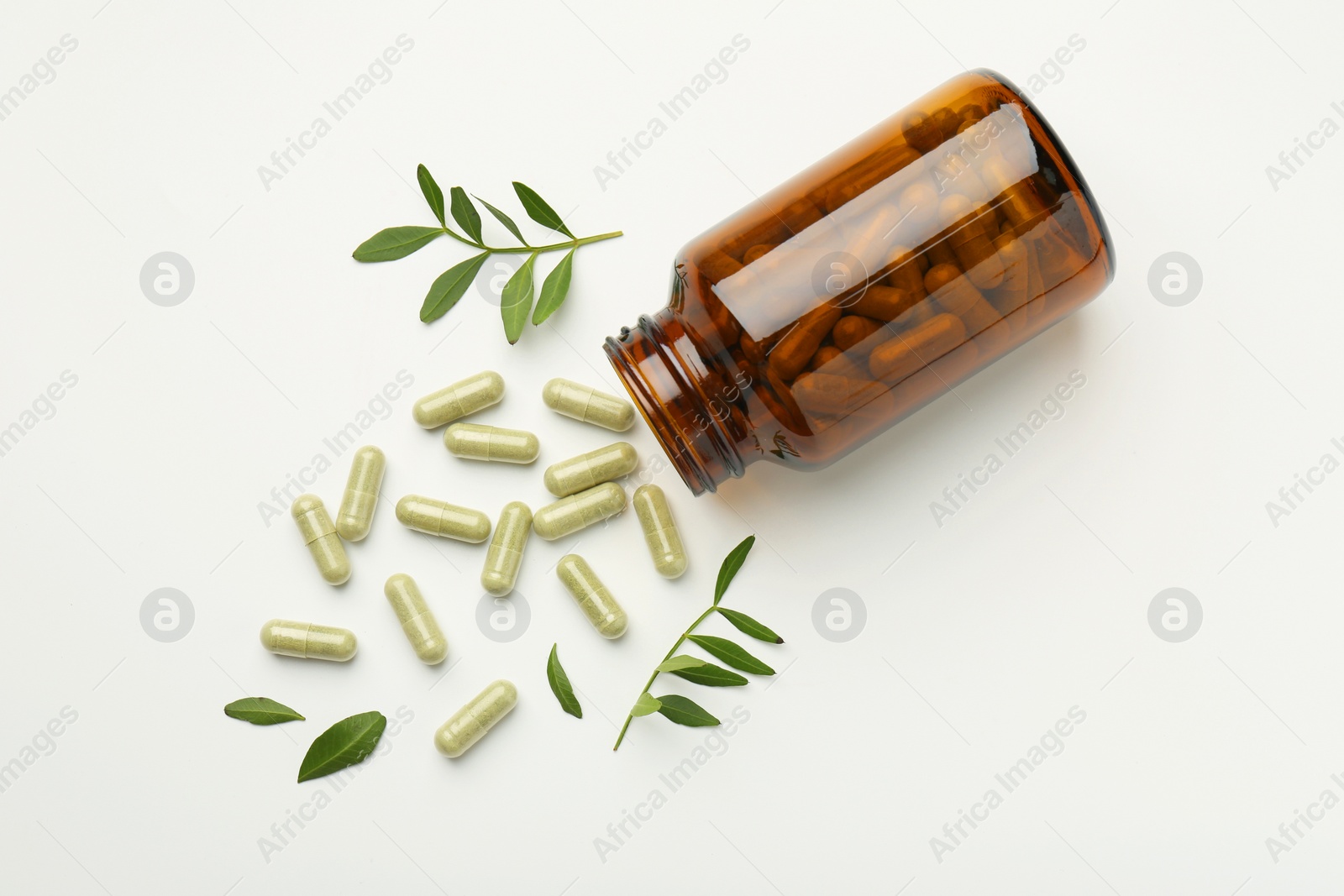 Photo of Bottle, vitamin capsules and leaves on white background, flat lay