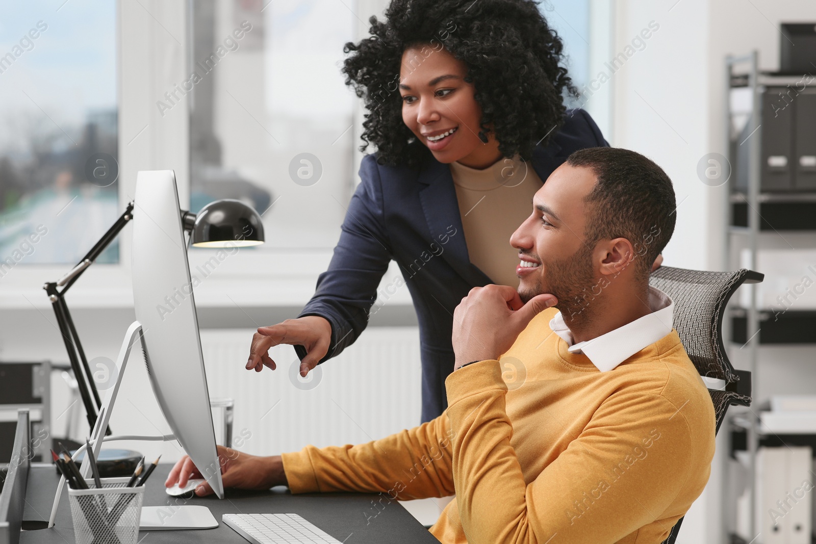 Photo of Young colleagues working together at table in office