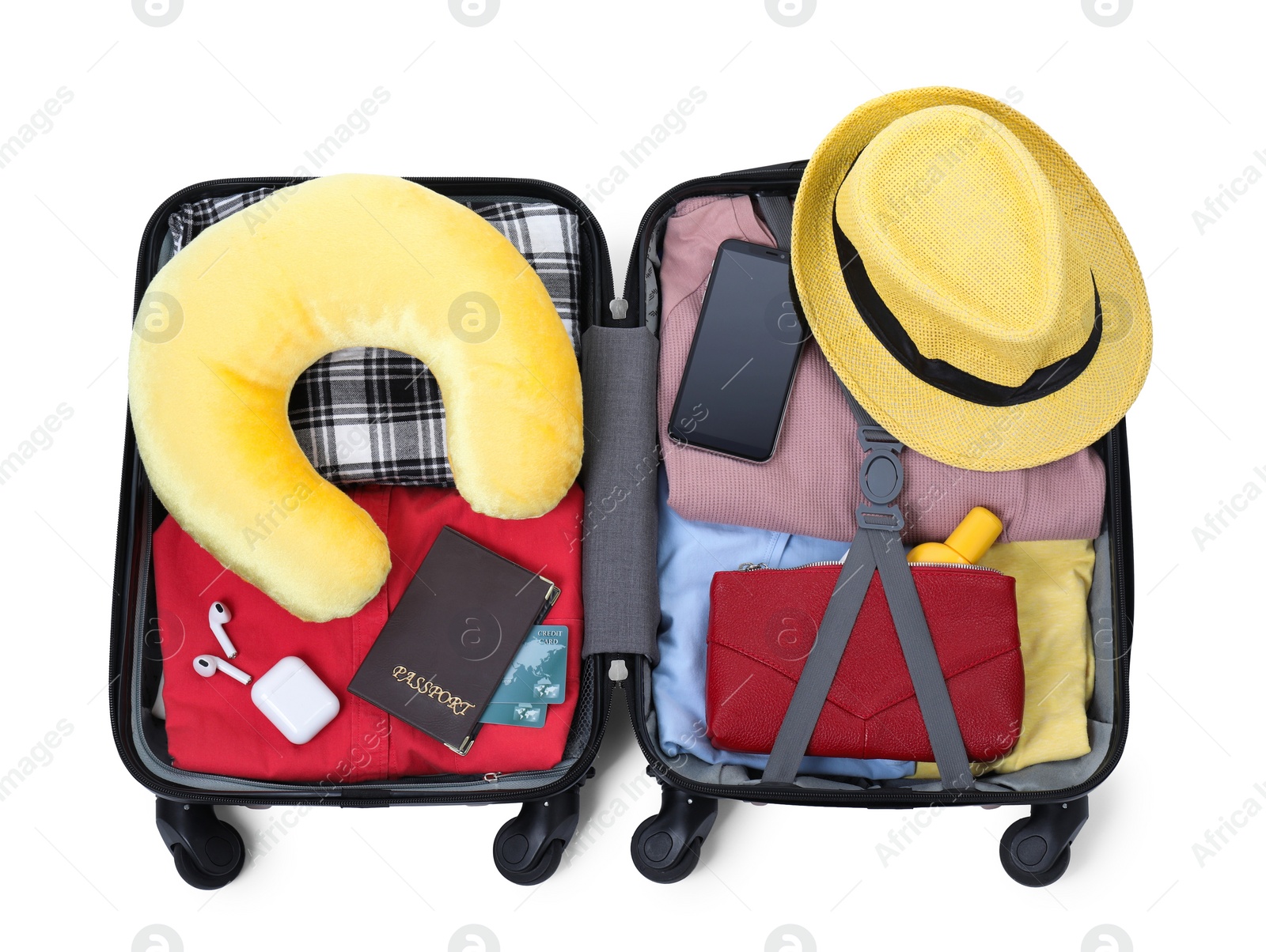 Photo of Soft travel pillow, hat, passports and other items in open suitcase isolated on white, top view