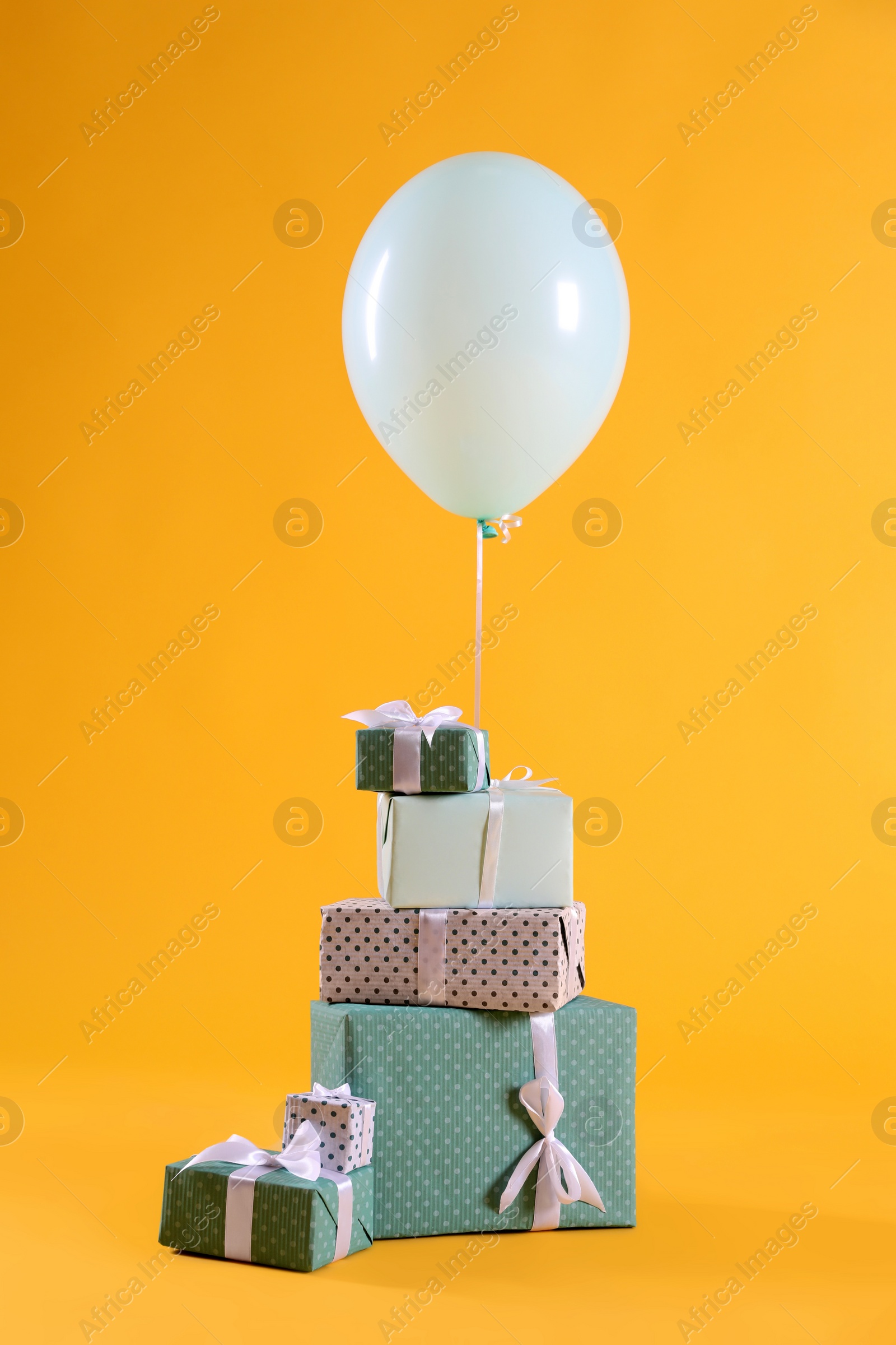 Photo of Many gift boxes and balloon on yellow background