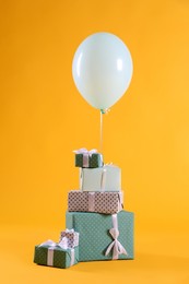 Photo of Many gift boxes and balloon on yellow background