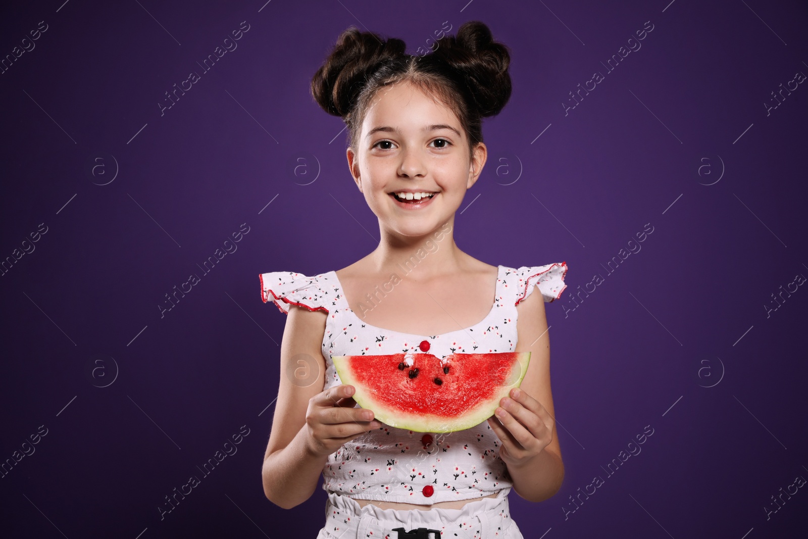 Photo of Cute little girl with watermelon on purple background