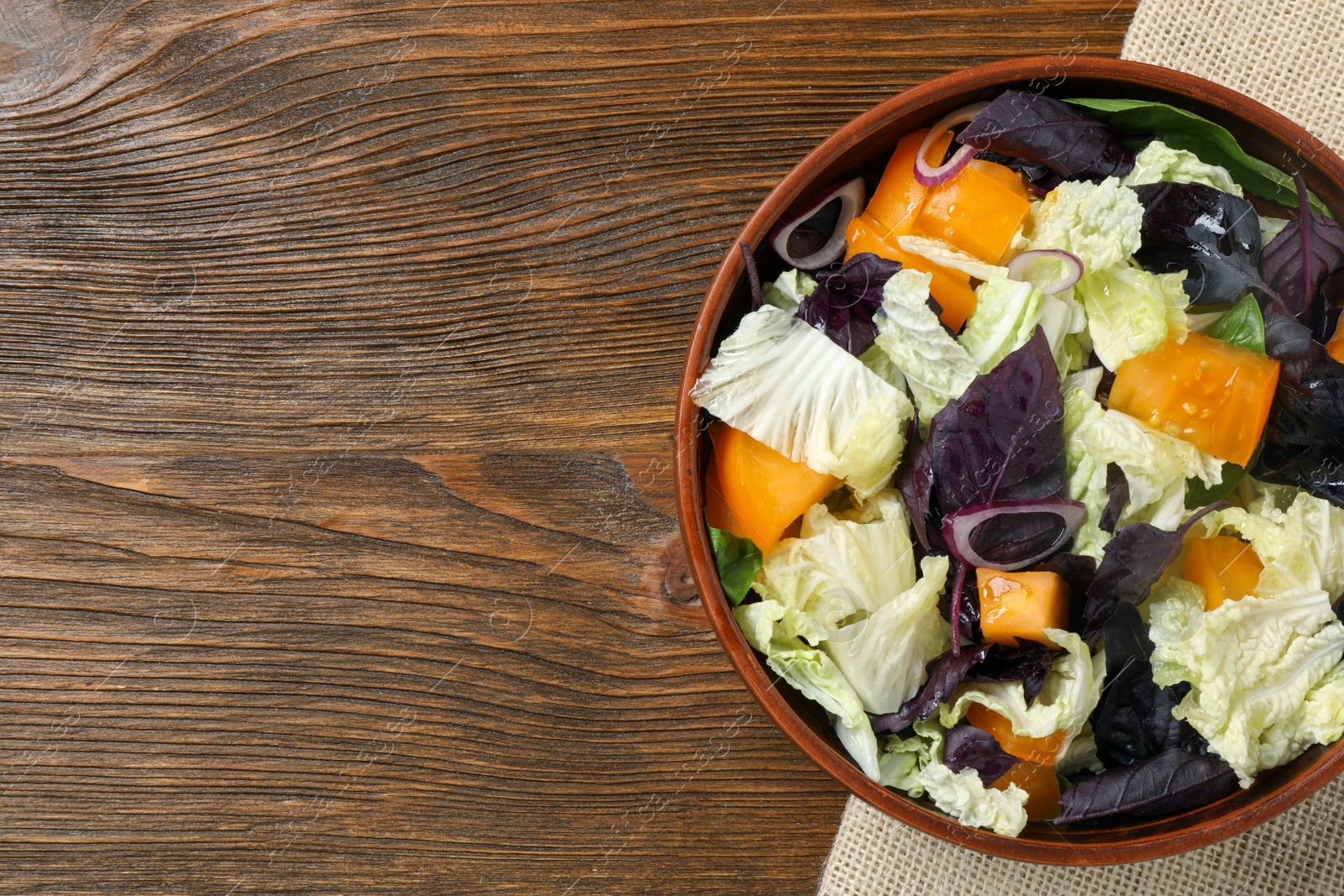 Photo of Delicious salad with Chinese cabbage, tomato and basil on wooden table, top view. Space for text