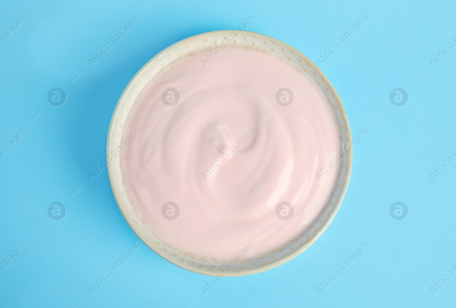 Photo of Tasty organic yogurt on light blue background, top view