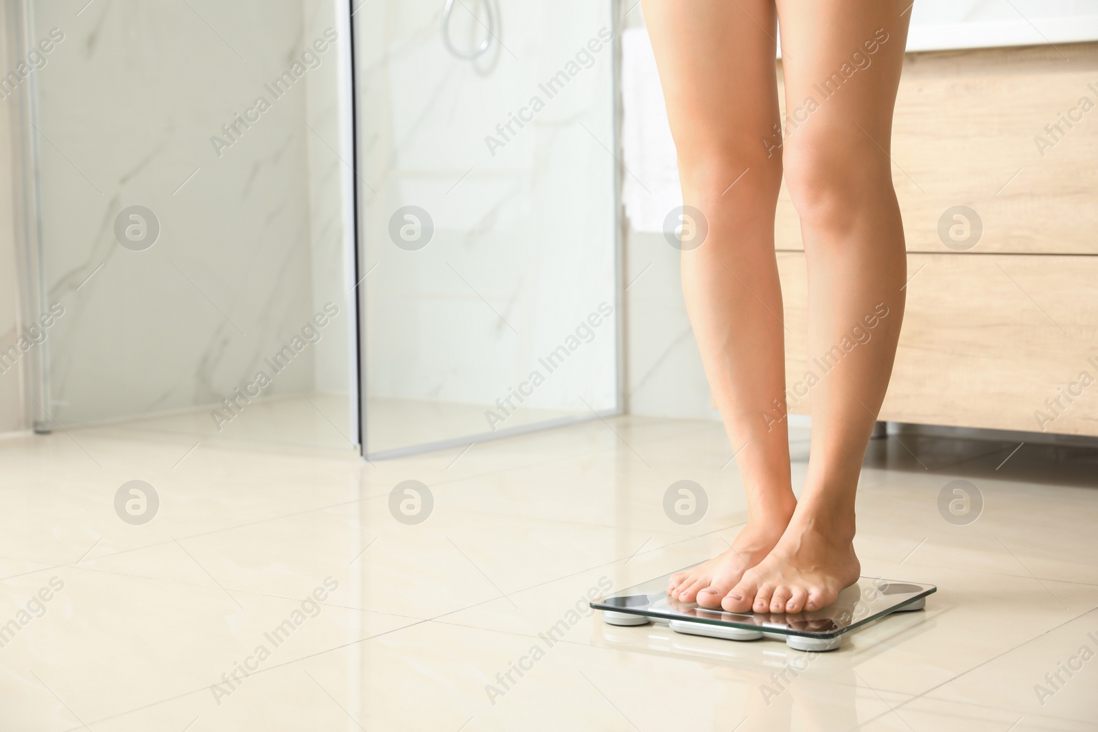 Photo of Woman standing on scales in bathroom, space for text. Overweight problem