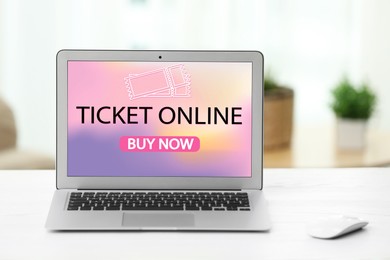 Image of Buying tickets online. Laptop with open website or application on table