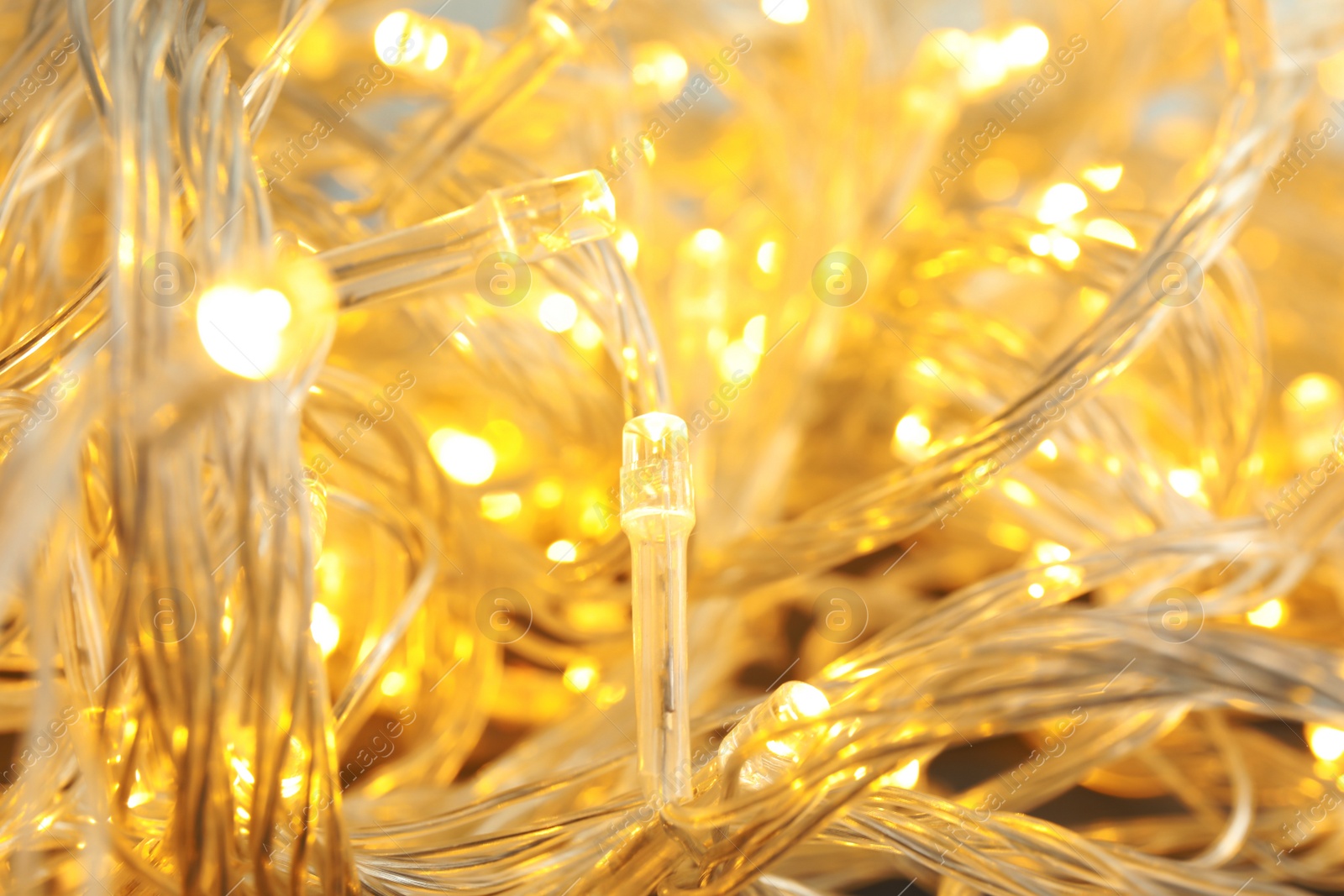 Photo of Glowing Christmas lights, closeup. Beautiful festive illumination