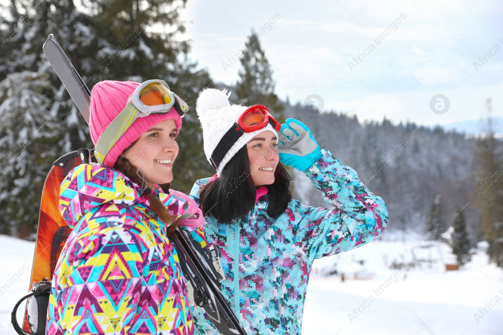 Photo of Friends resting on hill at mountain resort. Winter vacation