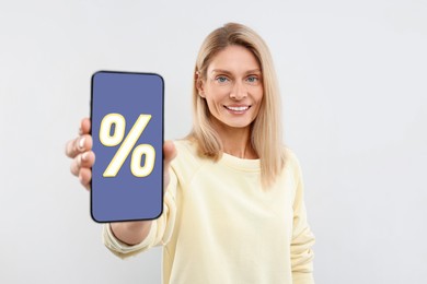 Image of Discount, offer, sale. Woman showing mobile phone with percent sign on screen, white background