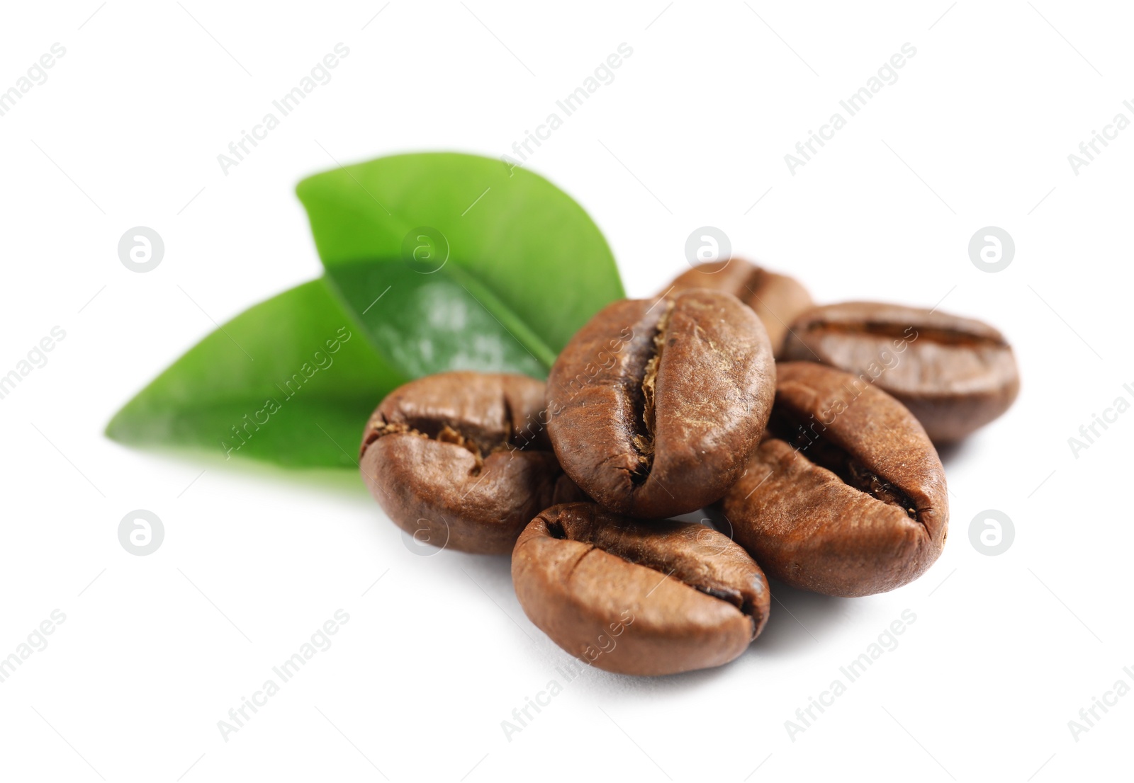 Photo of Roasted coffee beans and fresh green leaves on white background