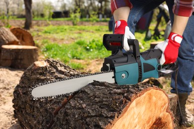 Man sawing wooden log on sunny day, closeup