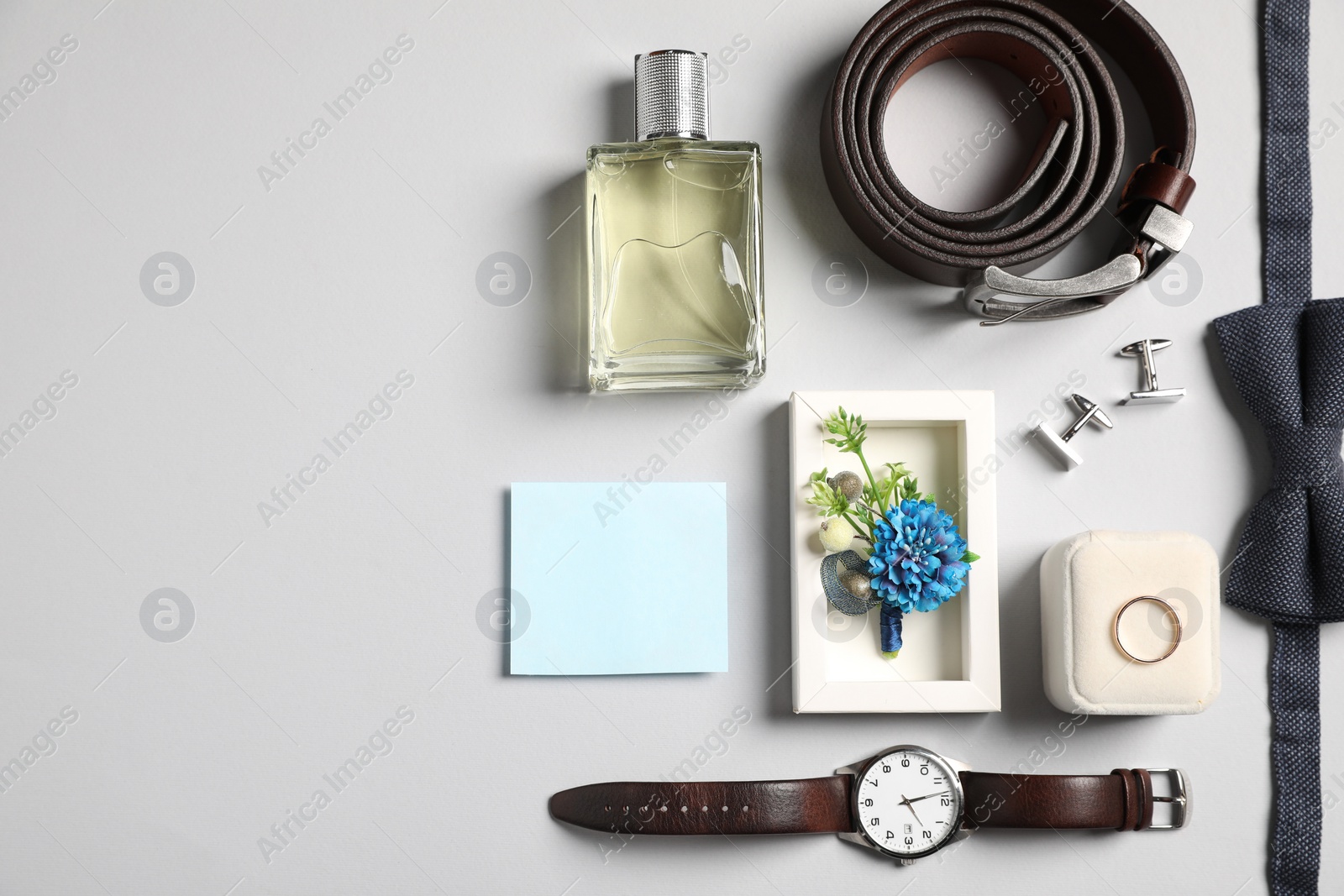 Photo of Wedding stuff. Flat lay composition with stylish boutonniere on light gray background, space for text