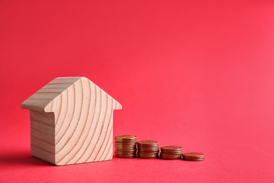 House model and coins on color background. Space for text