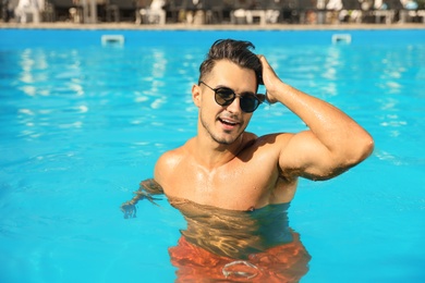 Photo of Young man in pool on sunny day