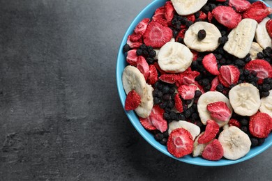 Photo of Bowl of dried fruits on grey table, top view. Space for text