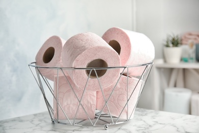 Photo of Bowl with toilet paper rolls on table