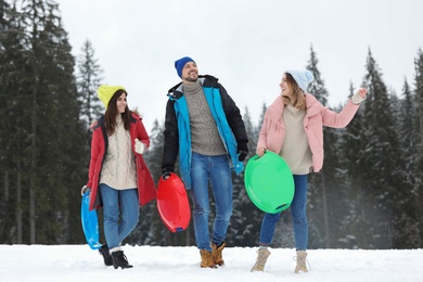 Photo of People with plastic sleds outdoors. Winter vacation