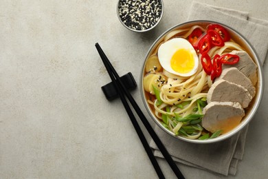 Delicious ramen in bowl served on light textured table, flat lay with space for text. Noodle soup