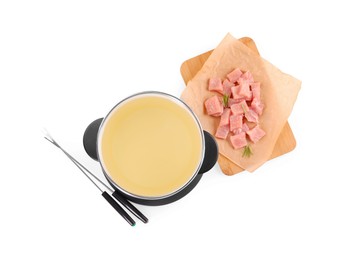 Photo of Oil in fondue pot, forks and pieces of raw meat isolated on white, top view