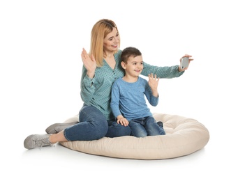 Mother and her son using video chat on smartphone, white background