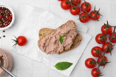 Photo of Delicious liverwurst sandwich and ingredients on white tiled table, flat lay