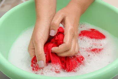 Woman washing color clothes in basin, closeup