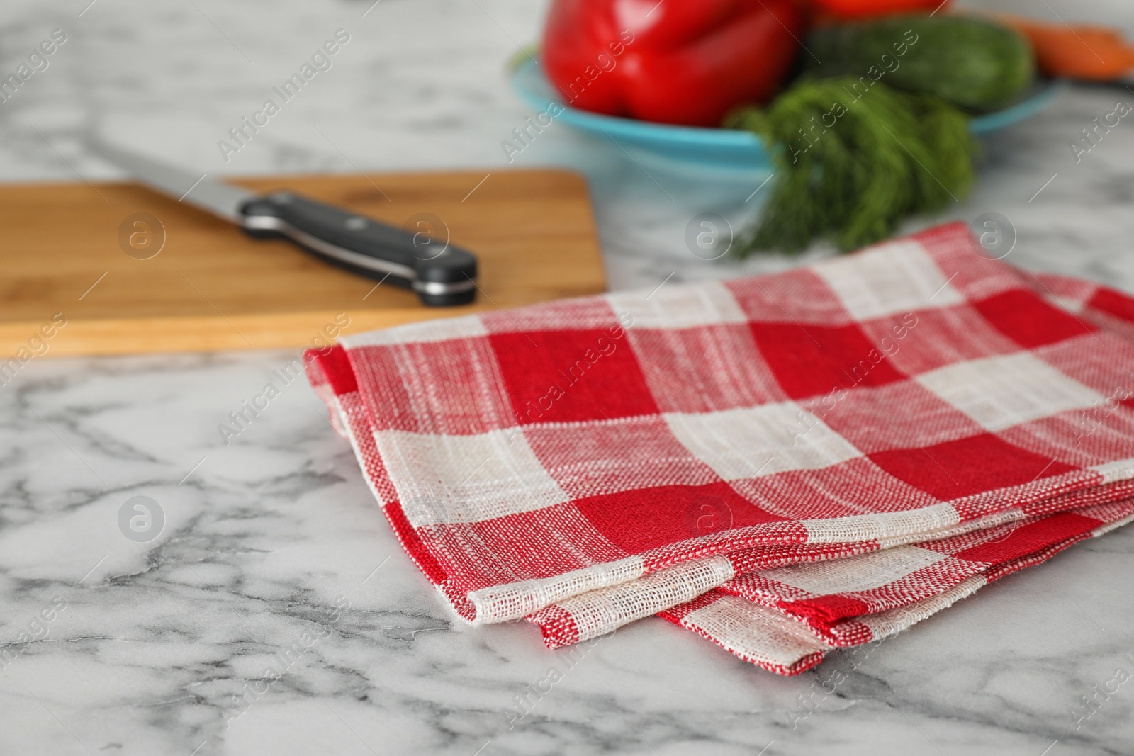 Photo of Checkered kitchen towel on white marble table, closeup