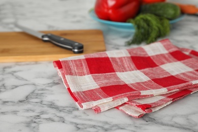 Checkered kitchen towel on white marble table, closeup