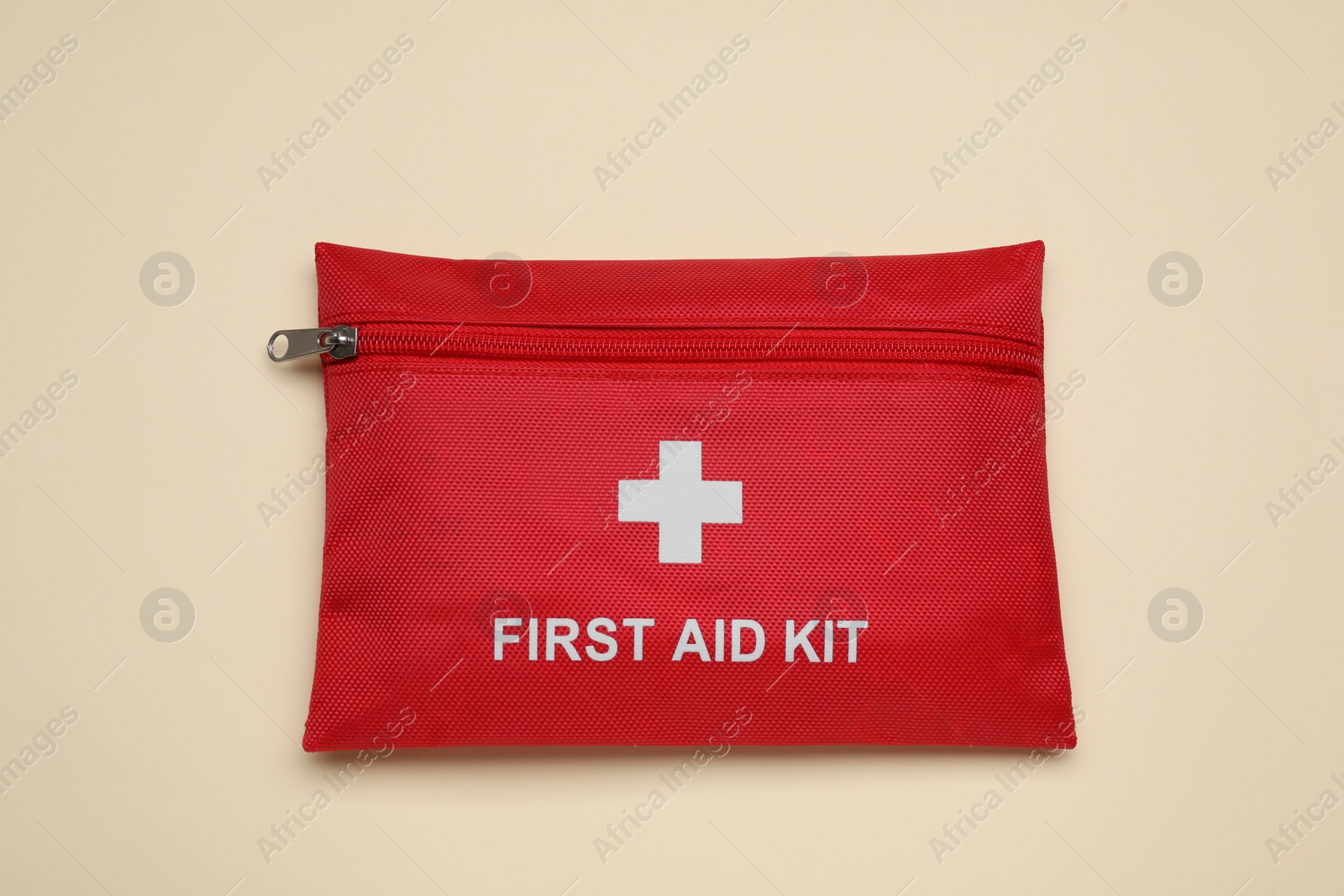 Photo of First aid kit on beige background, top view