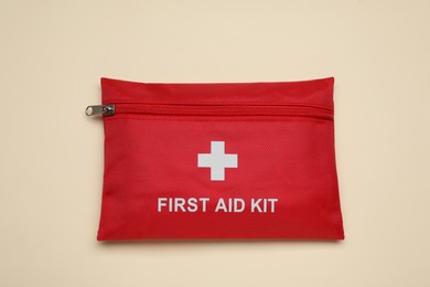 Photo of First aid kit on beige background, top view