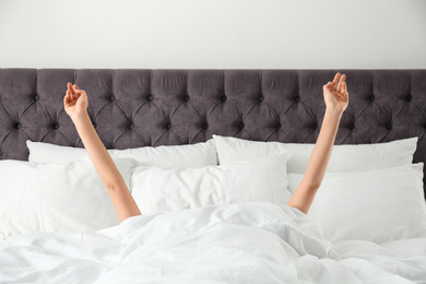 Photo of Woman awakening in bed, closeup. Lazy morning