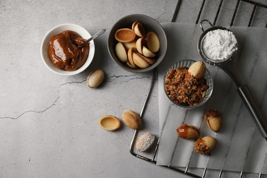 Delicious walnut shaped cookies with condensed milk on grey table, flat lay