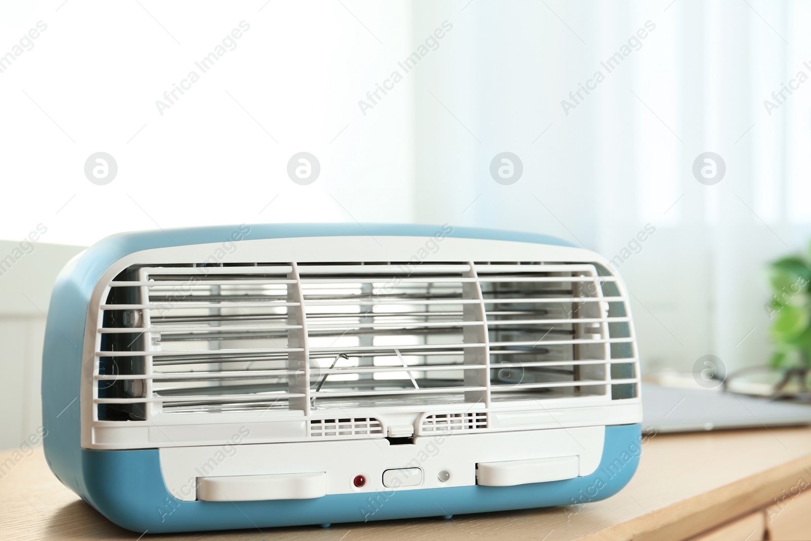 Photo of Modern air purifier on wooden table in room